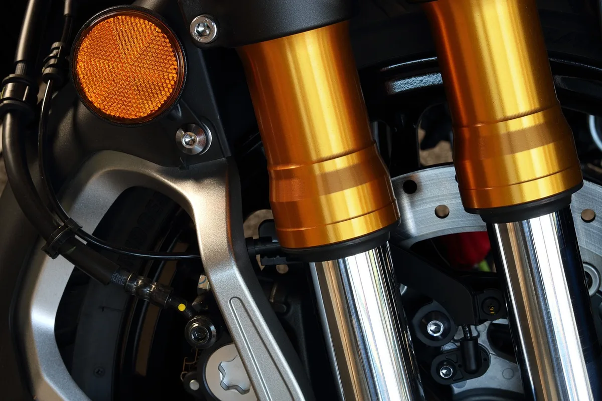 Inspection visuelle d'un amortisseur moto pour détecter les fuites d'huile et l'usure des joints