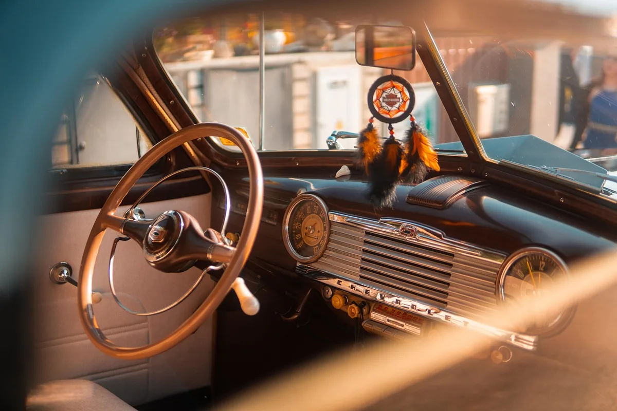Garage avec plusieurs voitures de collection et étagères d'accessoires