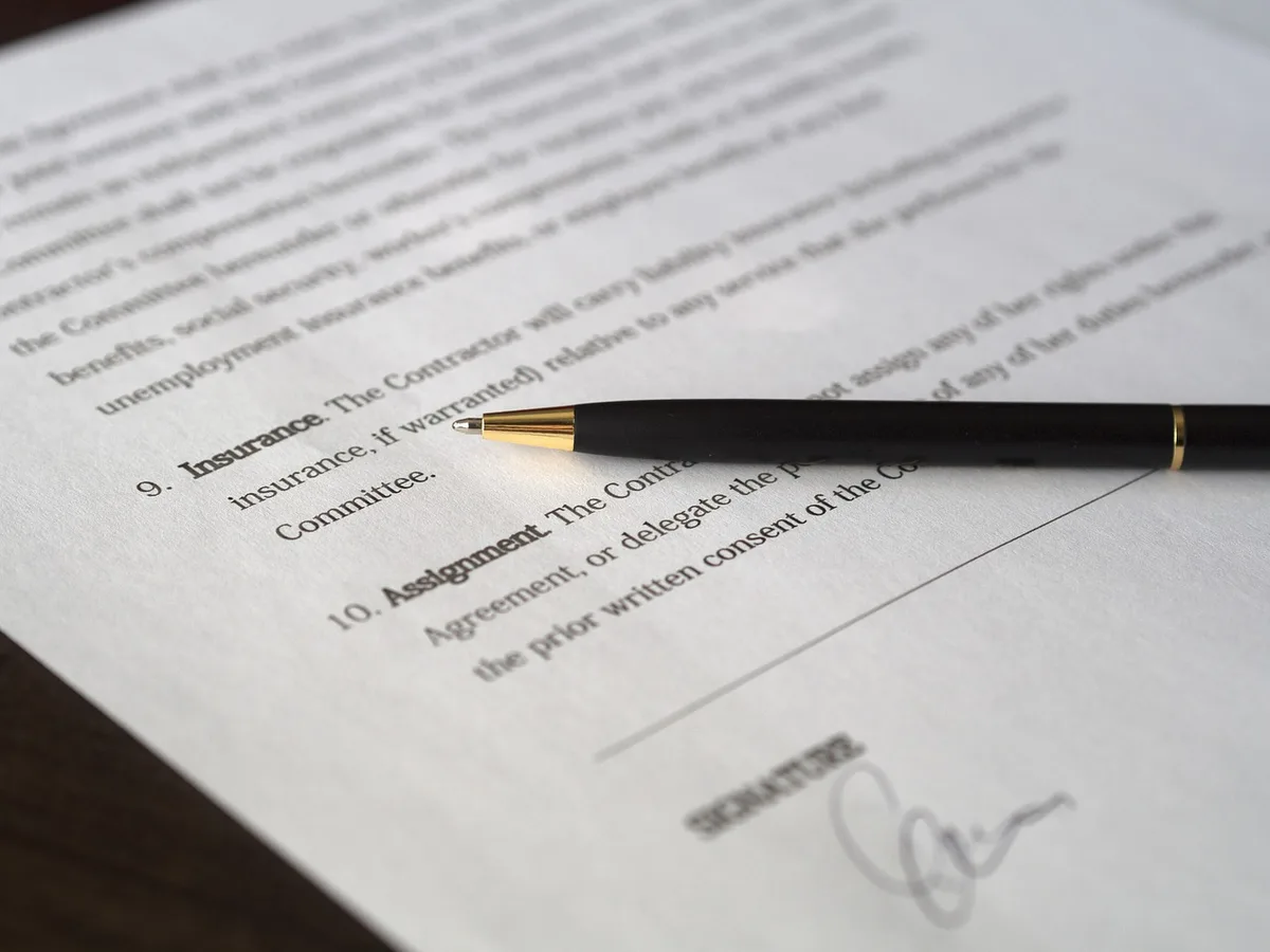 Contrat de prêt auto et documents posés sur une table en lumière du jour