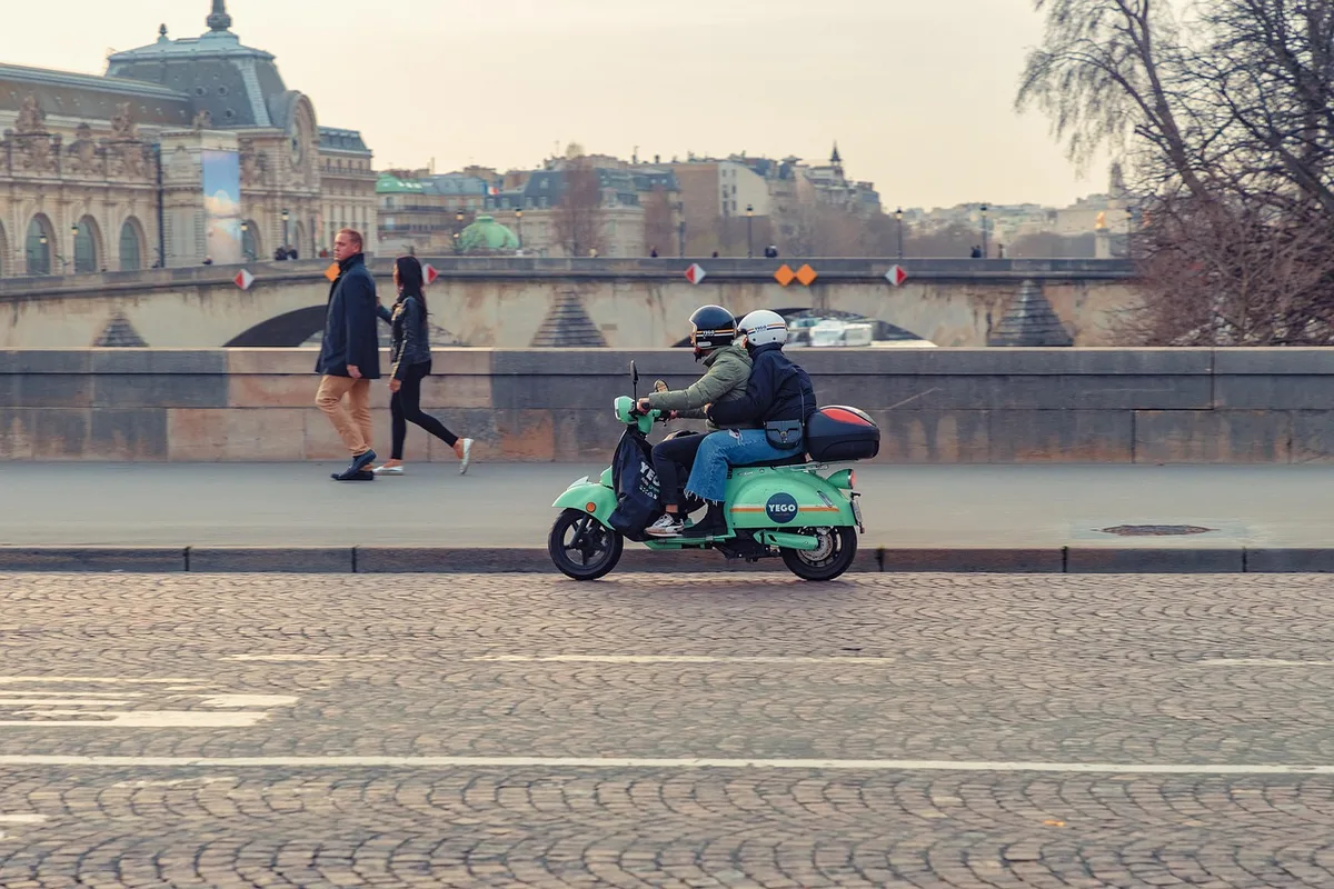 Voltmètre mesurant la tension d'une batterie de moto posée sur une table