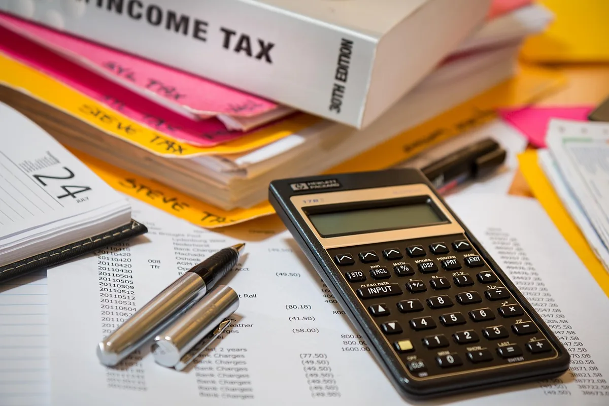 Calculatrice et formulaire fiscal sur un bureau pour estimer la réduction d'impôt Pinel