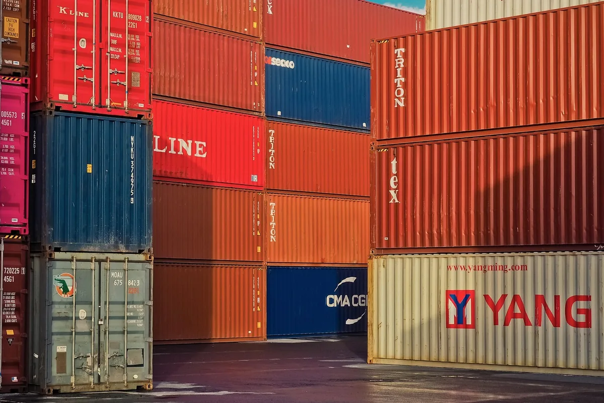 Conteneurs et caisses prêtes à l'export devant une usine automobile