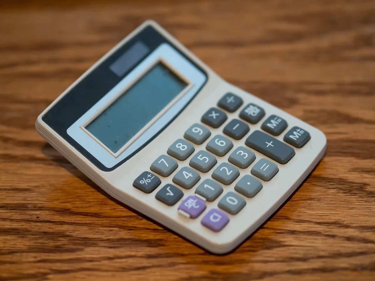 Calculatrice et documents montrant la répartition des composants du prix du carburant