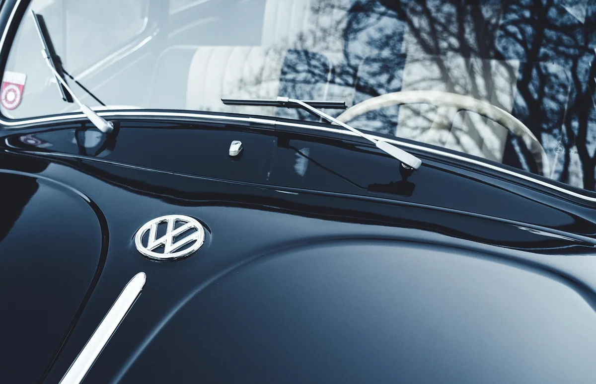 Main préparant une zone de carrosserie, ponçage et dégraissage visibles