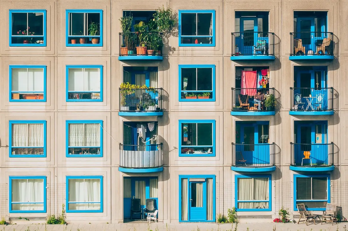 Locataire et propriétaire feuilletant une checklist dans un appartement lumineux