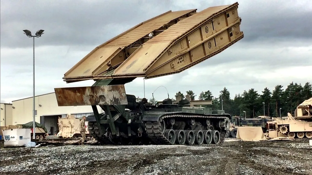 Entrée d'une base militaire avec véhicules garés et un portail de sécurité